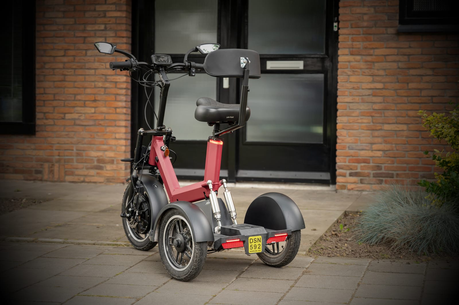 Detailbeeld van zadel en rugsteun op een elektrische driewielfiets